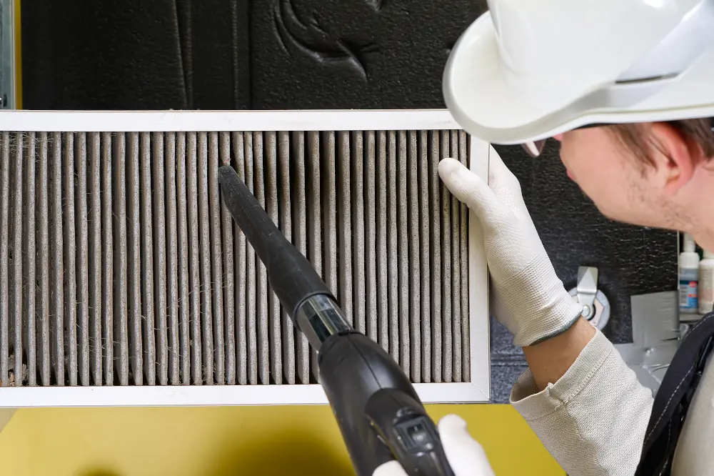 Contractor cleaning an air filter